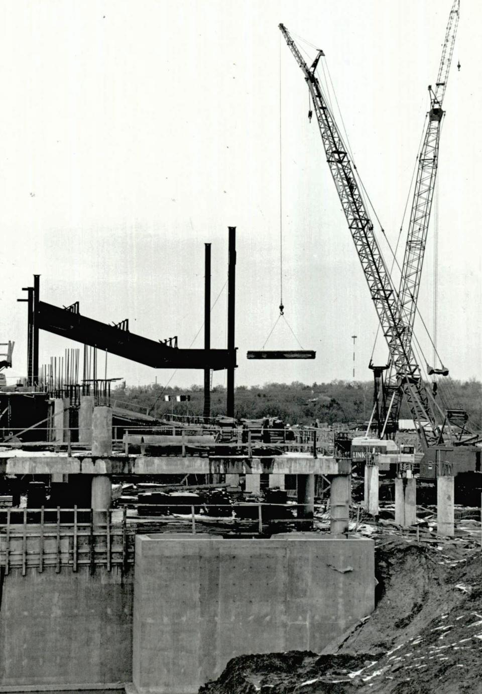 Construction workers move around beams with cranes in December 1987 as they work on the grandstand area at Remington Park.