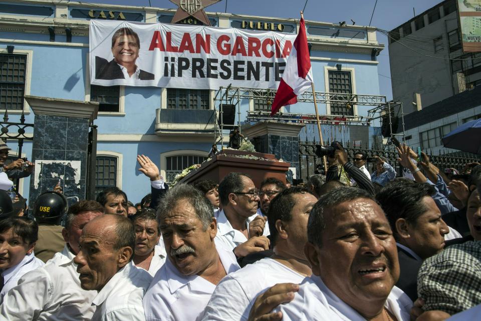 Men carry the coffin of Peru's late President Alan Garcia outside his party's headquarters where his wake was held, during his funeral procession in Lima, Peru, Friday, April 19, 2019. Garcia shot himself in the head and died Wednesday as officers waited to arrest him in a massive graft probe that has put the country's most prominent politicians behind bars and provoked a reckoning over corruption. (AP Photo/Rodrigo Abd)