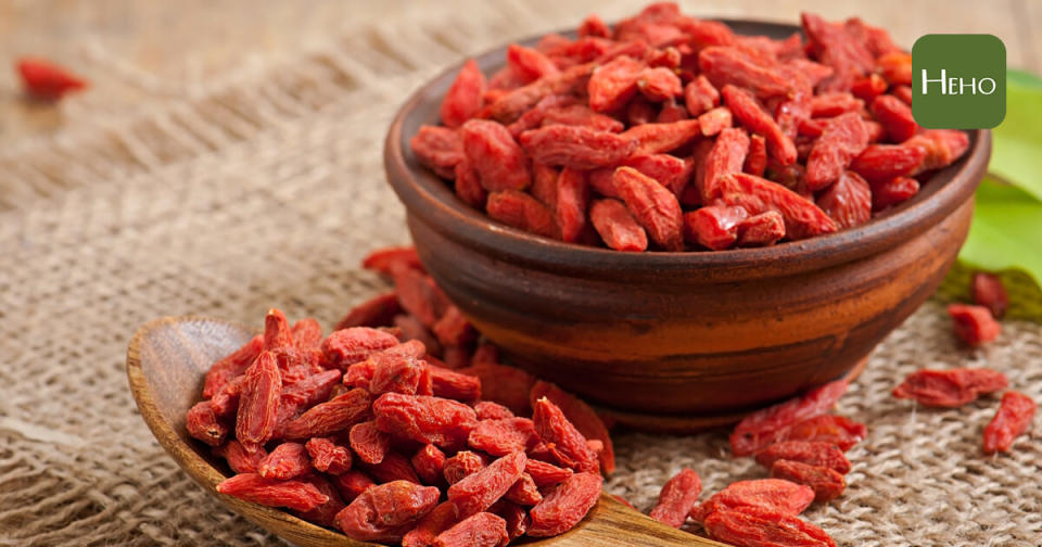 Red dried goji berries in wooden spoon