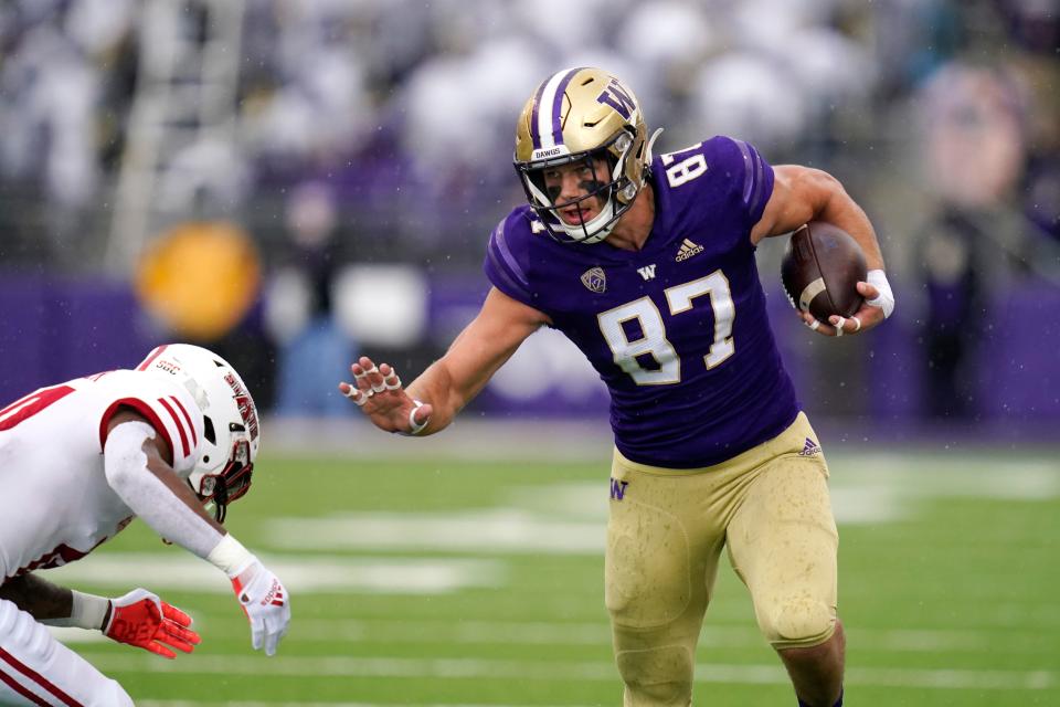 Washington's Cade Otton (87) tries to avoid a tackle as he runs with the ball against Arkansas State in the first half of an NCAA college football game, Saturday, Sept. 18, 2021, in Seattle. (AP Photo/Elaine Thompson)