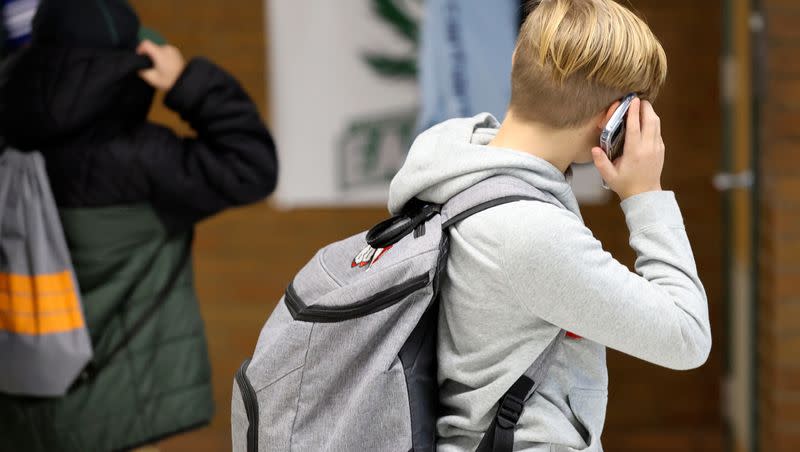 A student uses a cellphone after school at Evergreen Junior High School in Millcreek on Wednesday, Jan. 10, 2024. Phones are banned at Evergreen during the school day but are allowed after the final bell rings.