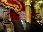 Afghanistan's presidential candidate and former foreign minister Zalmai Rassoul, center, Habiba Sarabi, one of Rassoul’s vice presidents, left, and Mohammad Nadir Naim listen to the national anthem during a meeting with supporters in Kabul, Afghanistan, Wednesday, March 26, 2014. Naim, grandson of Afghanistan’s King Zahir Shah, who died in 2007, announced his pullout, saying he was withdrawing for the sake of national unity. (AP Photo/Anja Niedringhaus)