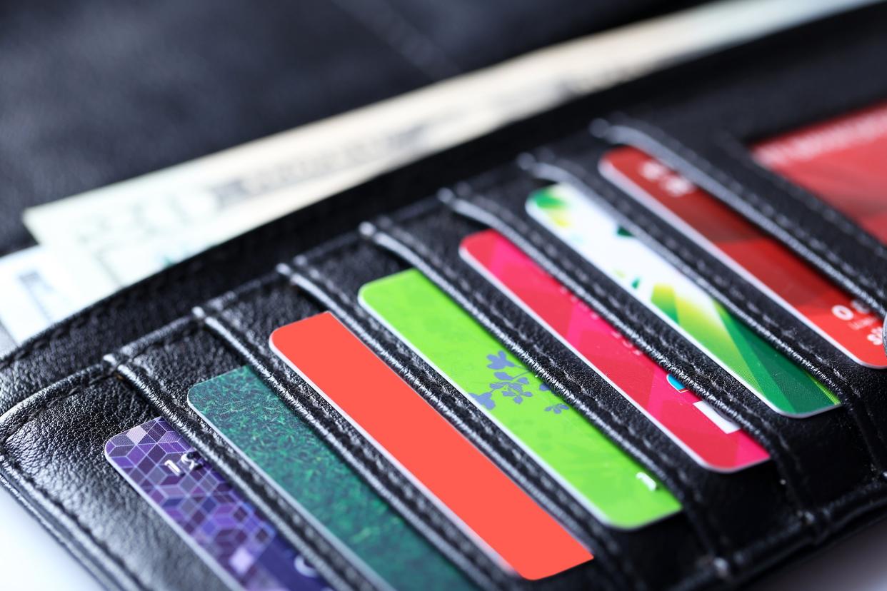 black leather wallet with colorful credit cards and money