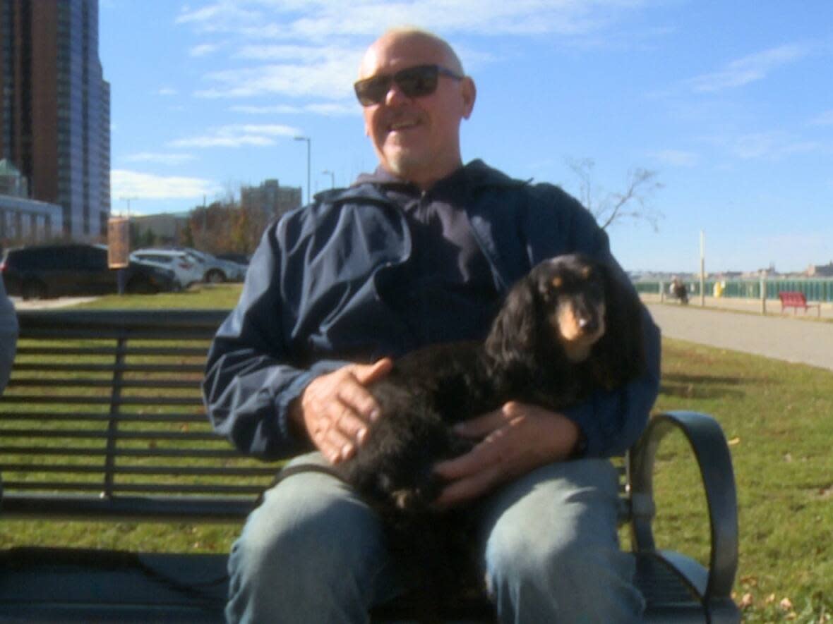 Patrick Dunn is enjoying the warm weather in Windsor with his wife and their dog, Nico. Dunn is taking the suggestion that Windsor is in for a mild winter with a grain of salt. (TJ Dhir/CBC - image credit)