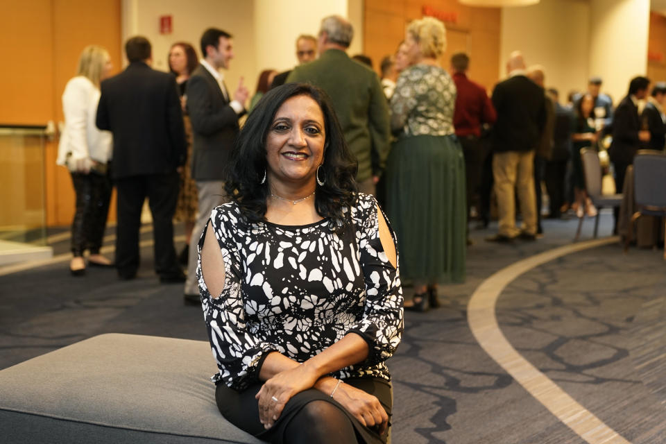 Shobha Surya poses for a photo at the Ajinomoto Health and Nutrition North America holiday party on Friday, Dec. 9, 2022, in Schaumburg, Ill. Say goodbye to virtual wine tasting, and practice your karaoke. Company holiday parties are making a comeback. After more than two years of working in pajama bottoms and clinking glasses over Zoom, many office workers are yearning for a bit of glamour, or at least a sense of normalcy. Surya was so excited the party was back on this year that she picked out her black-and-white cocktail dress two months in advance. (AP Photo/Charles Rex Arbogast)