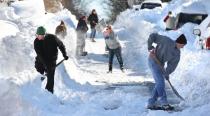Residents of W. Leicester St. in Winchester, Va. join forces to shovel out on Sunday, Jan. 24, 2016, after an historic snowstorm dumped more than 30 inches of snow on the city Friday night and Saturday. [Jeff Taylor/The Winchester Star via AP]