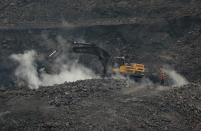 In this Oct. 23, 2019, photo, an excavator is used at an open-cast mine in the village of Rajapur in Jharia, a remote corner of eastern Jharkhand state, India. The fires started in coal pits in eastern India in 1916. More than a century later, they are still spewing flames and clouds of poisonous fumes into the air, forcing residents to brave sizzling temperatures, deadly sinkholes and toxic gases. (AP Photo/Aijaz Rahi)