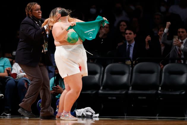Security appears to be pulling one protester by the hair during the demonstration at the WNBA game. (Photo: Sarah Stier via Getty Images)