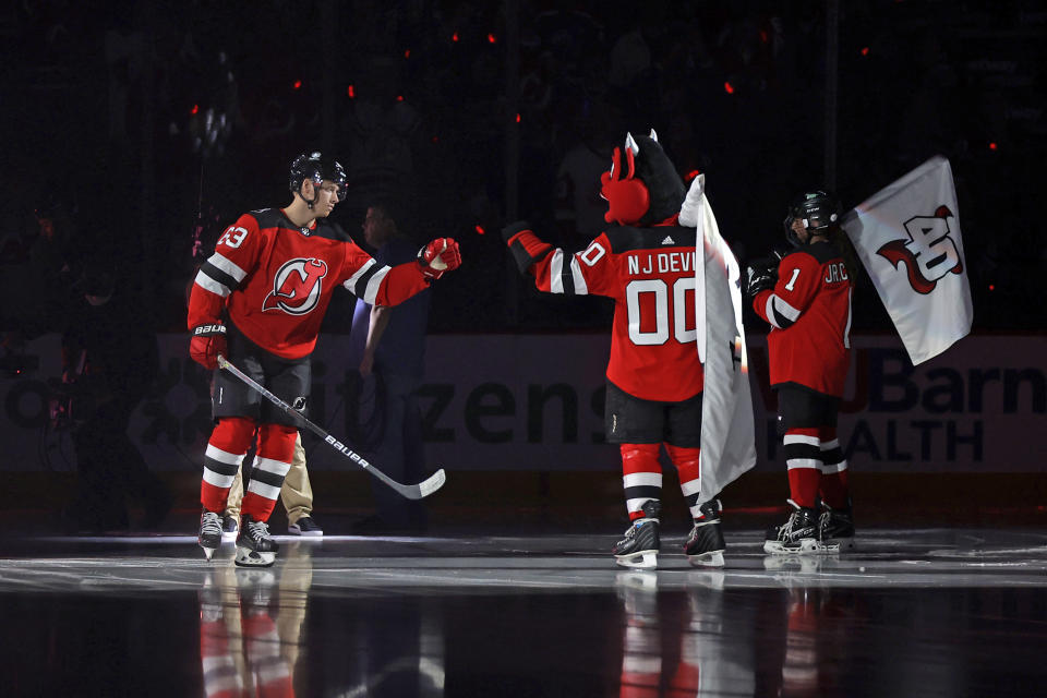 New Jersey Devils left wing Jesper Bratt fist-bumps the team's mascot as he is introduced before the first period of an NHL hockey game against the Detroit Red Wings Saturday, Oct. 15, 2022, in Newark, N.J. (AP Photo/Adam Hunger)