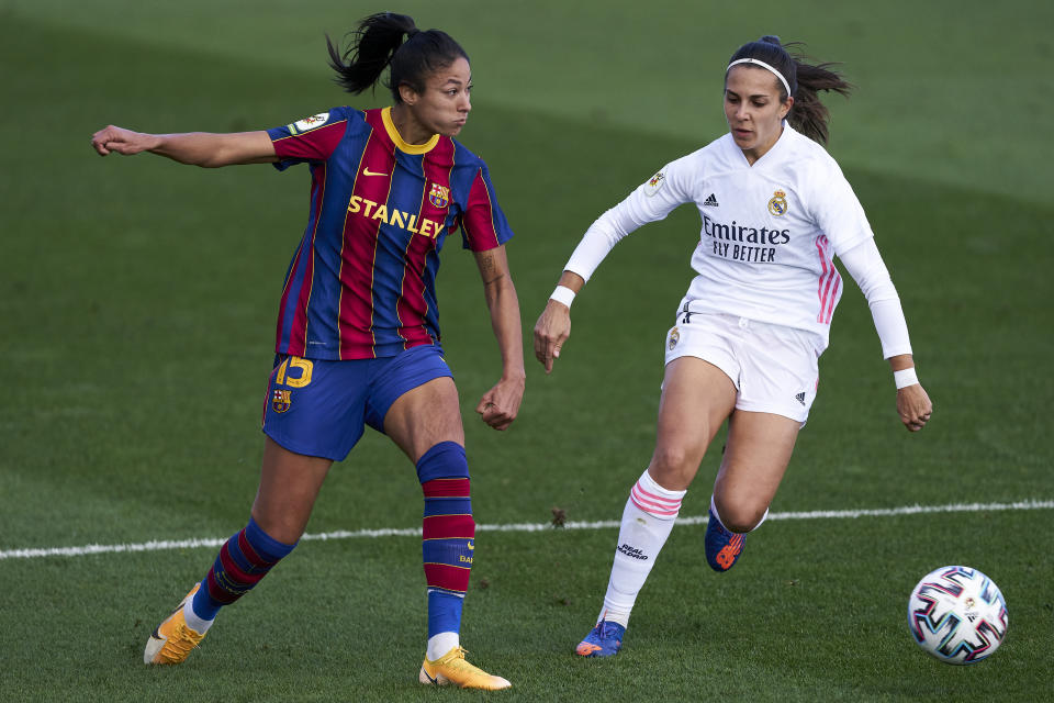 Futbolistas del Real Madrid y el Barcelona femenino luchan por la pelota.