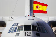 A Spanish flag is waved from a plane carrying some of the 17 tons of silver and gold coins scooped up from a Spanish warship, Nuestra Senora de las Mercedes, that sank during a 1804 gunbattle, after its arrival at the Torrejon De Ardoz military airbase, near Madrid, on Saturday Feb. 25, 2012. (AP Photo/Daniel Ochoa de Olza)