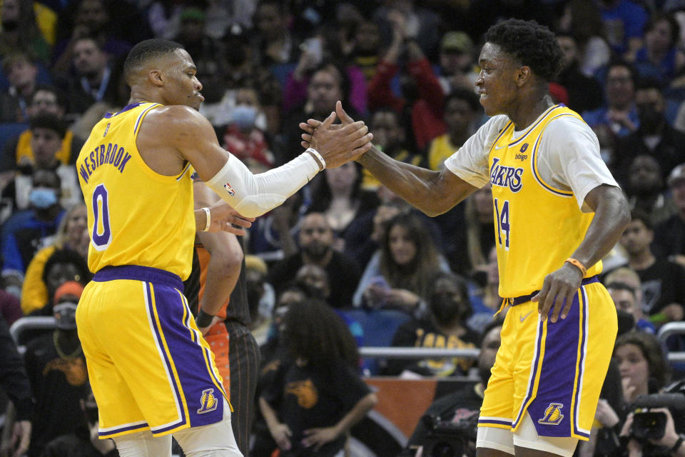 Los Angeles Lakers guard Russell Westbrook (0) congratulates forward Stanley Johnson (14) after Johnson scored a three-point basket during the second half of an NBA basketball game against the Orlando Magic, Friday, Jan. 21, 2022, in Orlando, Fla. (AP Photo/Phelan M. Ebenhack)