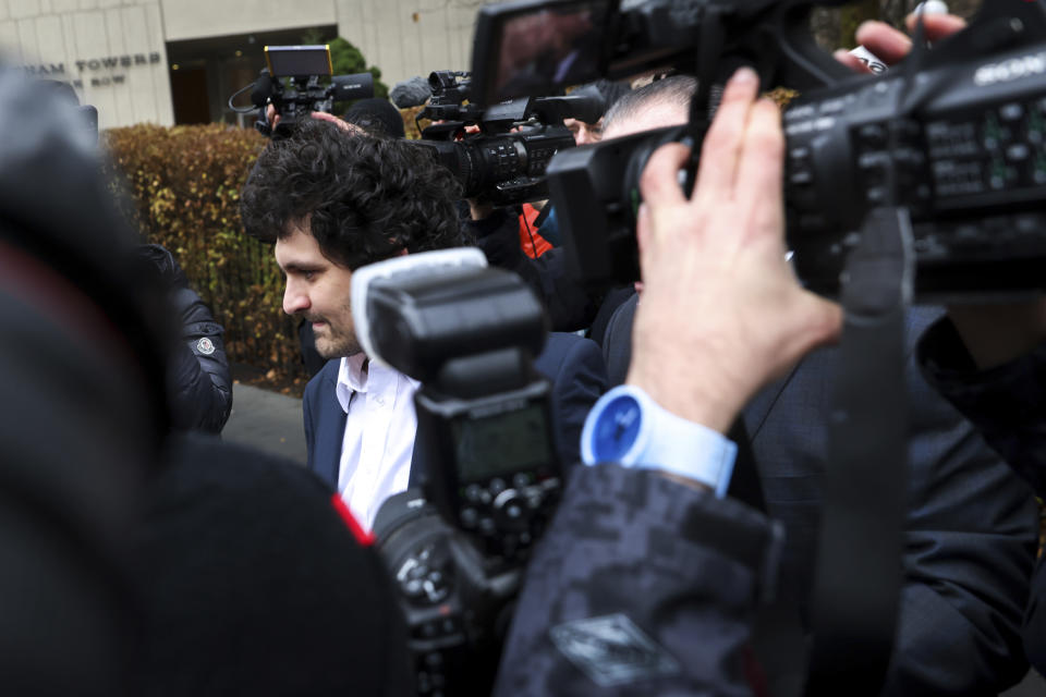 FILE - FTX founder Sam Bankman-Fried, center, is escorted to his car from the U.S. District Court in Manhattan, Thursday, Dec. 22, 2022, in New York. A judge agreed to a request by prosecutors to keep it secret that two of Bankman-Fried's executive associates had turned against him so that the cryptocurrency entrepreneur would agree not to fight extradition from the Bahamas to the United States, according to transcripts of plea deals made public Friday, Dec. 23, 2022. (AP Photo/Julia Nikhinson)