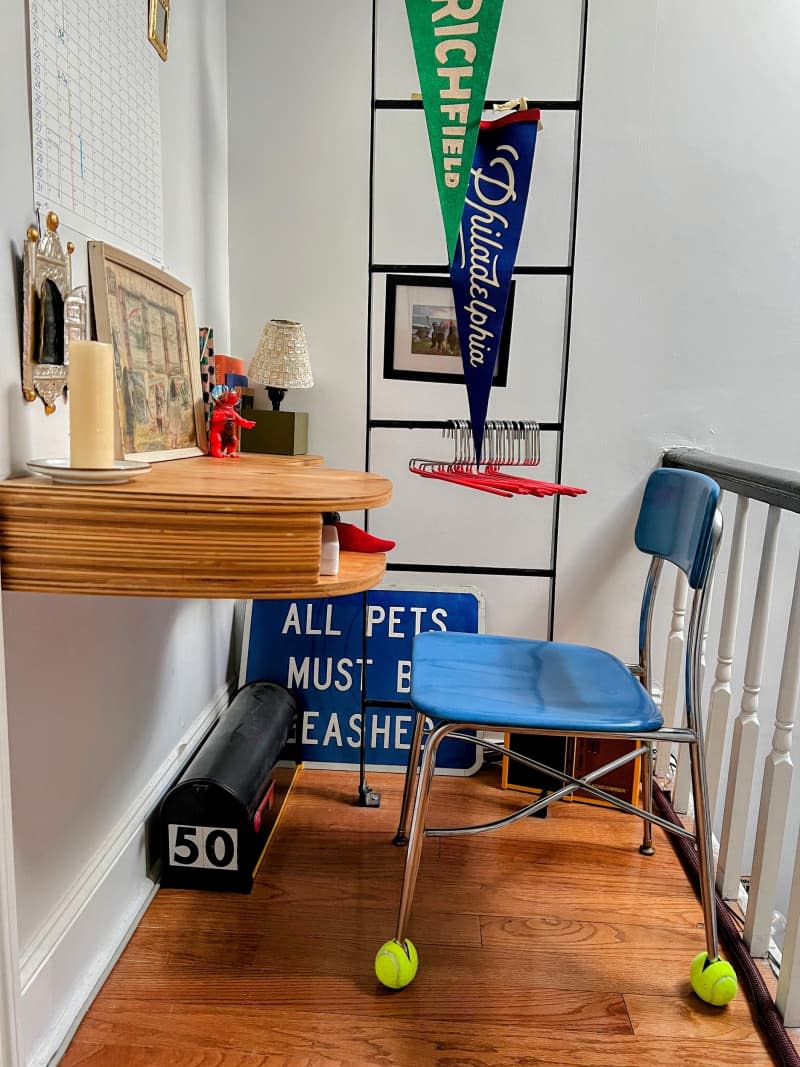 Blue desk chair next to a ladder with decorative flags hanging on it.