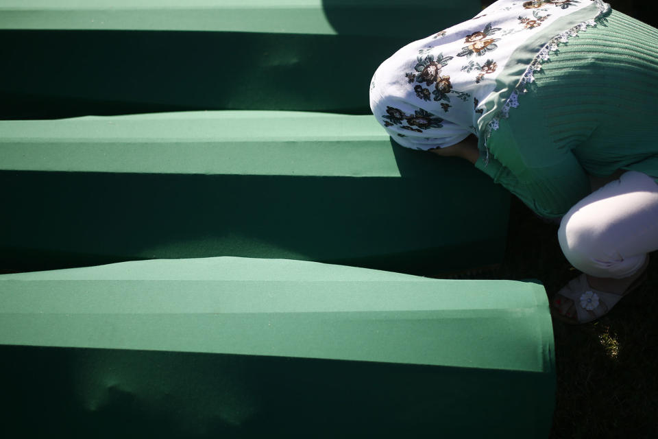 <p>A woman mourns near coffins of her relatives, who are newly identified victims of the 1995 Srebrenica massacre, which are lined up for a joint burial in Potocari near Srebrenica, Bosnia and Herzegovina, July 11, 2017. (Photo: Dado Ruvic/Reuters) </p>