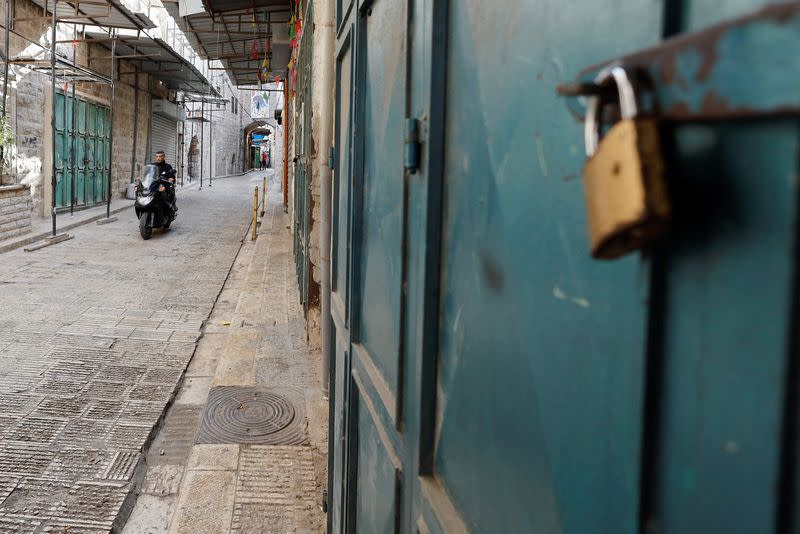 A man rides a moped past closed shops, during a general strike, after Palestinian Den of Lions member Tamer Kilani was killed in an explosion, in Nablus