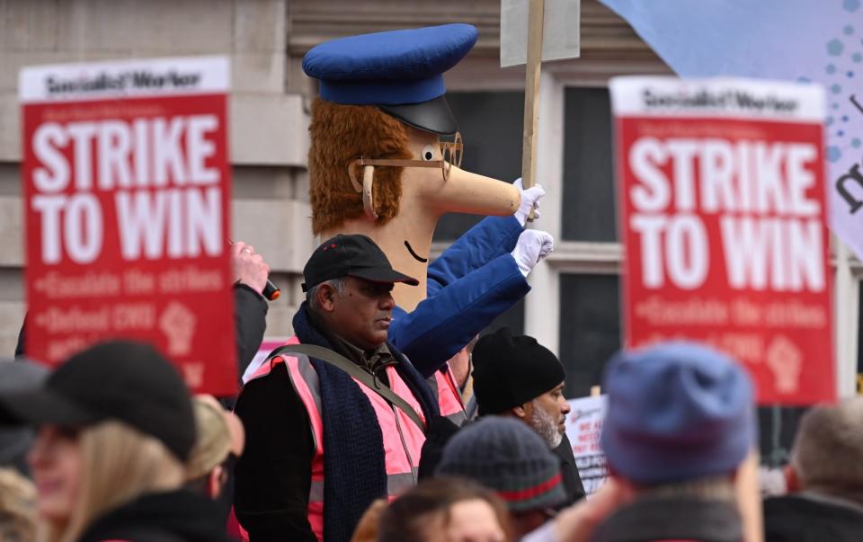 A demonstrator dressed as Postman Pat joins striking mail workers and supporters marching to Parliament Square - Leon Neal/Getty Images