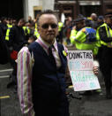 An Extinction Rebellion climate change protester holds a placard outside the Goldman Sachs office in the City of London, Thursday, April 25, 2019. The non-violent protest group, Extinction Rebellion, is seeking negotiations with the government on its demand to make slowing climate change a top priority. (AP Photo/Matt Dunham)