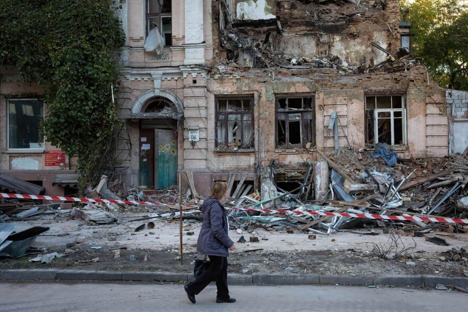 An elderly woman walks past an apartment building destroyed by a Russian drone strike, which local authorities consider to be Iranian-made unmanned aerial vehicles (UAVs) Shahed-136, in central Kyiv. At least four people have been killed as a result of a drone attack on a residential building in Kyiv on the morning of Octю 17, 2022. (Photo by Oleksii Chumachenko/SOPA Images/LightRocket via Getty Images)