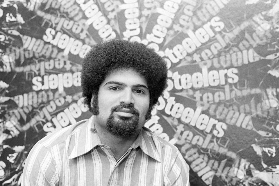 FILE - Pittsburgh Steelers running back Franco Harris, named as offensive rookie of the year by The Associated Press, is pictured before a collage of posters in the team offices in Pittsburgh, Jan. 2, 1973. Franco Harris, the Hall of Fame running back whose heads-up thinking authored “The Immaculate Reception,” considered the most iconic play in NFL history, died Wednesday, Dec. 21, 2022. He was 72. (AP Photo/Harry Cabluck, File)