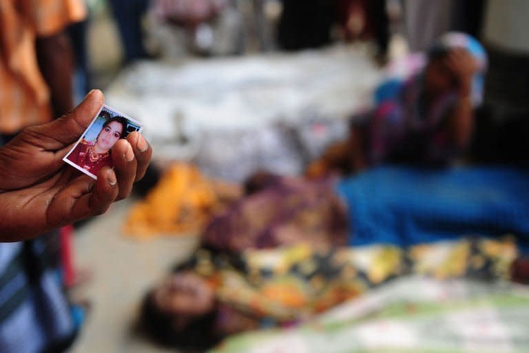 A Bangladeshi man holds his sister's portrait as he attempts to identify her among the bodies of those killed in the collapse of an eight-storey building in Savar, on the outskirts of Dhaka, on April 25, 2013