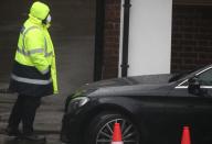 A security guard wears a surgical mask as he assists a car at a Coronavirus drive-through test centre at Parson's Green Medical Centre in London