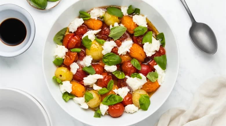 Roasted tomato caprese salad in white bowl