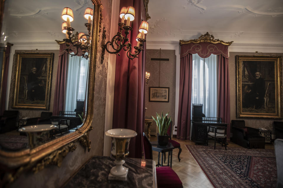 This Thursday, May 14, 2020 picture shows the Giuseppe Verdi suite where 19th century composer Giuseppe Verdi, pictured on the painting, stayed, in Milan, Italy. The hotel dates back to 1863. (AP Photo/Luca Bruno)