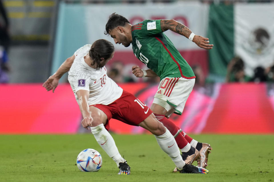 Mexico's Alexis Vega, right, and Poland's Grzegorz Krychowiak, battle for the ball during the World Cup group C soccer match between Mexico and Poland, at the Stadium 974 in Doha, Qatar, Tuesday, Nov. 22, 2022. (AP Photo/Aijaz Rahi)