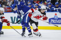 Toronto Maple Leafs left wing Matthew Knies (23) and New Jersey Devils centre Jack Hughes (86) compete for the puck during the second period of an NHL hockey game Tuesday, March 26, 2024, in Toronto. (Cole Burston/The Canadian Press via AP)