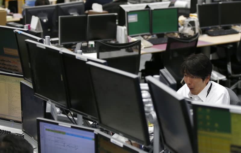 An employee of a foreign exchange trading company looks at monitors in Tokyo October 31, 2014. REUTERS/Toru Hanai/Files