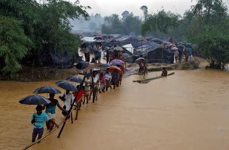 People cross a river from a Rohingya refugee camp in Cox's Bazar, Bangladesh, September 19, 2017. REUTERS/Cathal McNaughton