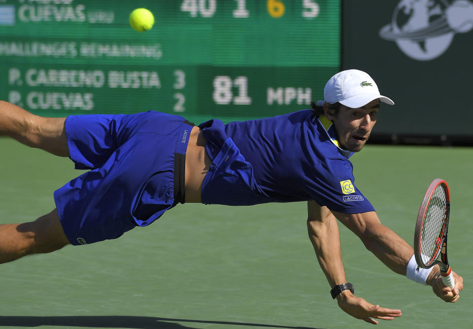 Pablo Cuevas, of Uruguay, dives to return a shot against Pablo Carreno Busta, of Spain, at the BNP Paribas Open tennis tournament, Thursday, March 16, 2017, in Indian Wells, Calif. (AP Photo/Mark J. Terrill)