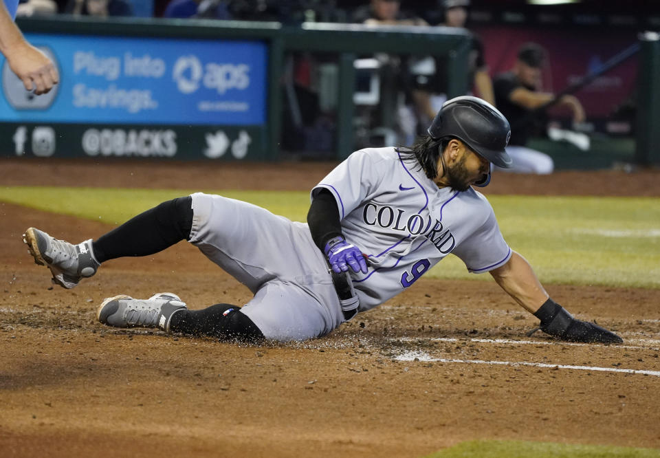 Colorado Rockies' Connor Joe slides across home plate to score against the Arizona Diamondbacks during the third inning of a baseball game Saturday July 9, 2022, in Phoenix. (AP Photo/Darryl Webb)