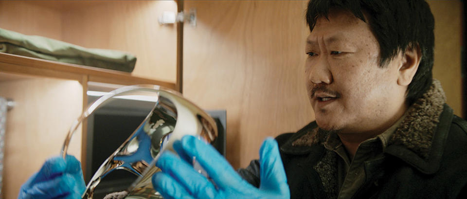 Benedict Wong, as a veteran cop working for a secret intelligence agency charged with protecting the world, examines an alien-made VR headset.