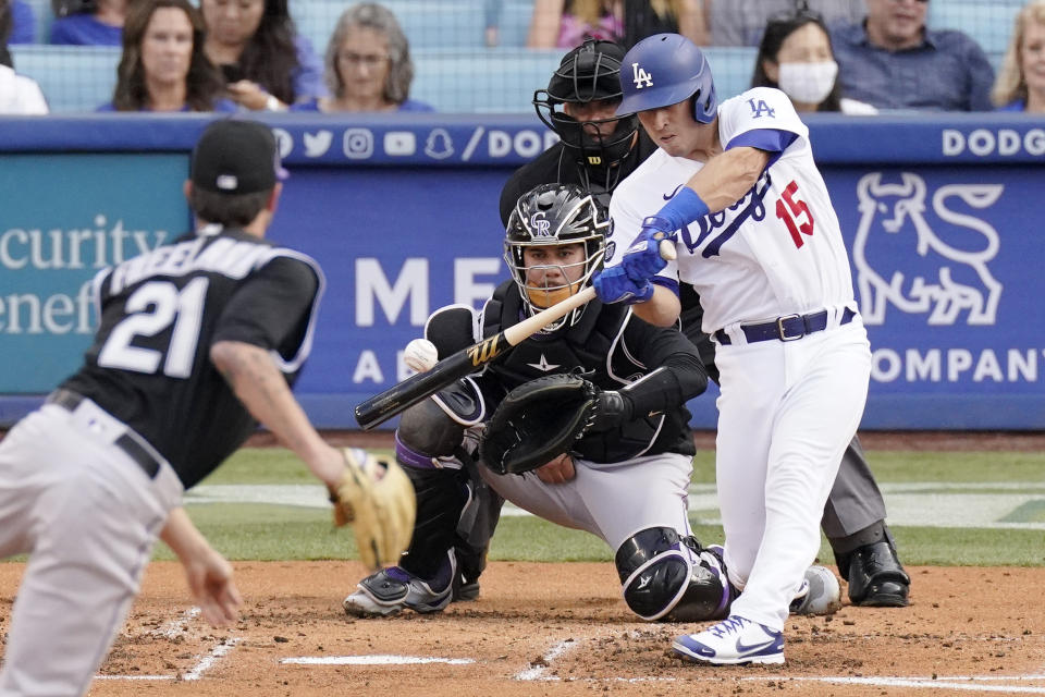 Los Angeles Dodgers' Austin Barnes, right, hits a solo home run as Colorado Rockies starting pitcher Kyle Freeland, left, watches along with catcher Dom Nunez, second from left, and home plate umpire Vic Carapazza during the second inning of a baseball game Saturday, July 24, 2021, in Los Angeles. (AP Photo/Mark J. Terrill)
