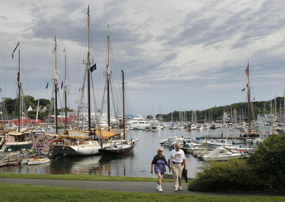 In this photo made Friday, Aug. 31, 2012, a couple strolls through a park by the harbor in Camden, Maine. The small coastal town is often cited in lists of best retirement places to move for people interested in cooler climates. (AP Photo/Robert F. Bukaty)