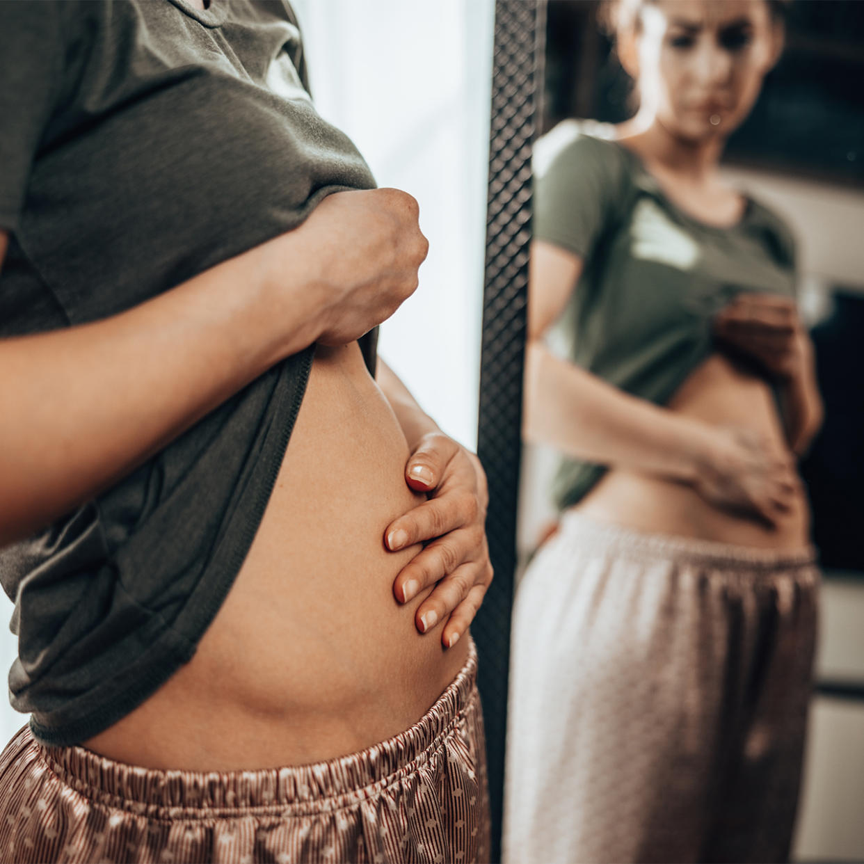 unhappy woman with bloated stomach pain