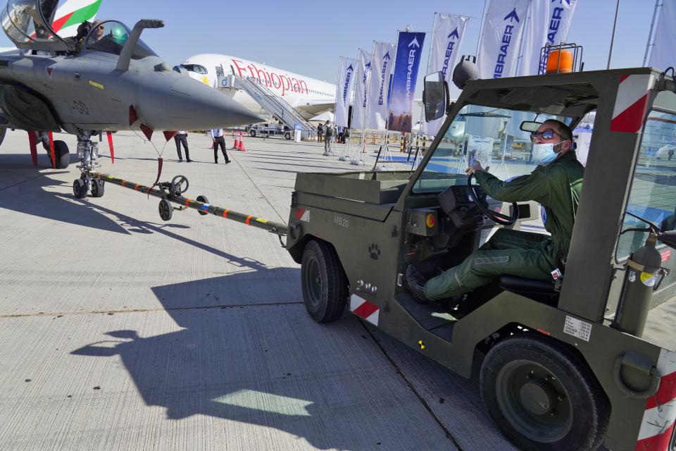 French airmen pull a Dassault Rafale fighter jet into position at the Dubai Air Show in Dubai, United Arab Emirates, Sunday, Nov. 14, 2021. The biennial Dubai Air Show opened Sunday as commercial aviation tries to shake off the coronavirus pandemic. (AP Photo/Jon Gambrell)