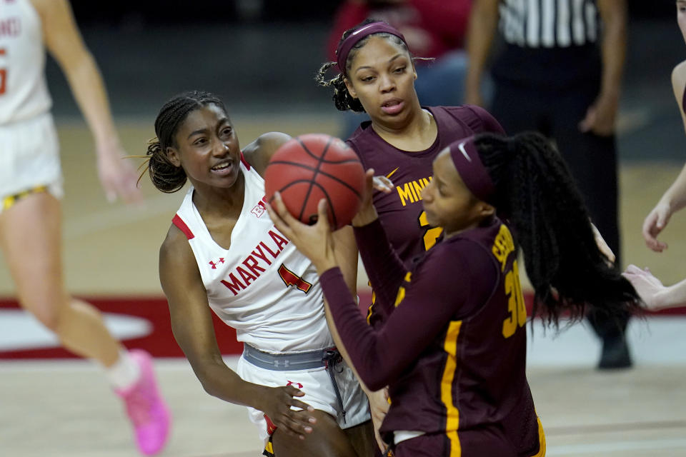 Maryland guard Diamond Miller, left, competes for a rebound with Minnesota center Klarke Sconiers, center, and forward Kadiatou Sissoko during the second half of an NCAA college basketball game, Saturday, Feb. 20, 2021, in College Park, Md. (AP Photo/Julio Cortez)