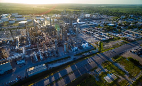 An oil refinery at sunset with long shadows.