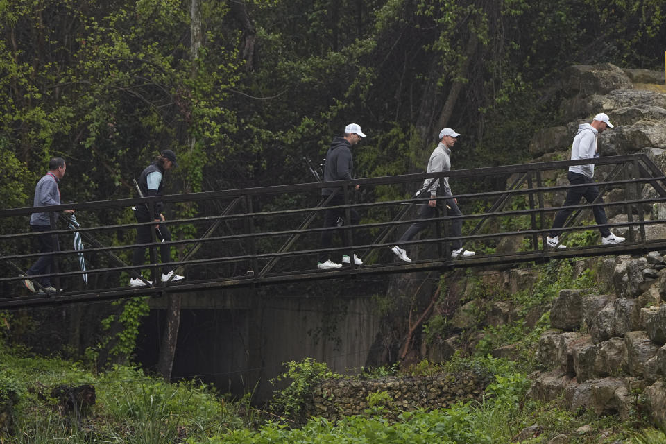 Rory McIlroy, of Northern Ireland, second from right, and Tommy Fleetwood, second from left, cross a bridge during a practice round for the Dell Technologies Match Play Championship golf tournament in Austin, Texas, Tuesday, March 21, 2023. (AP Photo/Eric Gay)