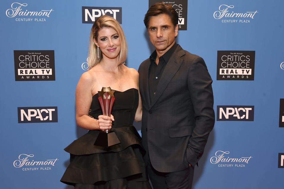 Kelly Rizzo, who accepted The Impact Award on behalf of the late Bob Saget, and John Stamos pose during the Fourth Annual Critics Choice Real TV Awards