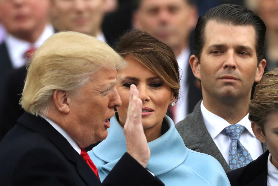 Donald Trump Jr. (R) watches as his father Donald Trump (L) is sworn in as the 45th president of the United States standing with first lady Melania Trump (C) during inauguration ceremonies at the U.S. Capitol in Washington, U.S. January 20, 2017.   REUTERS/Carlos Barria