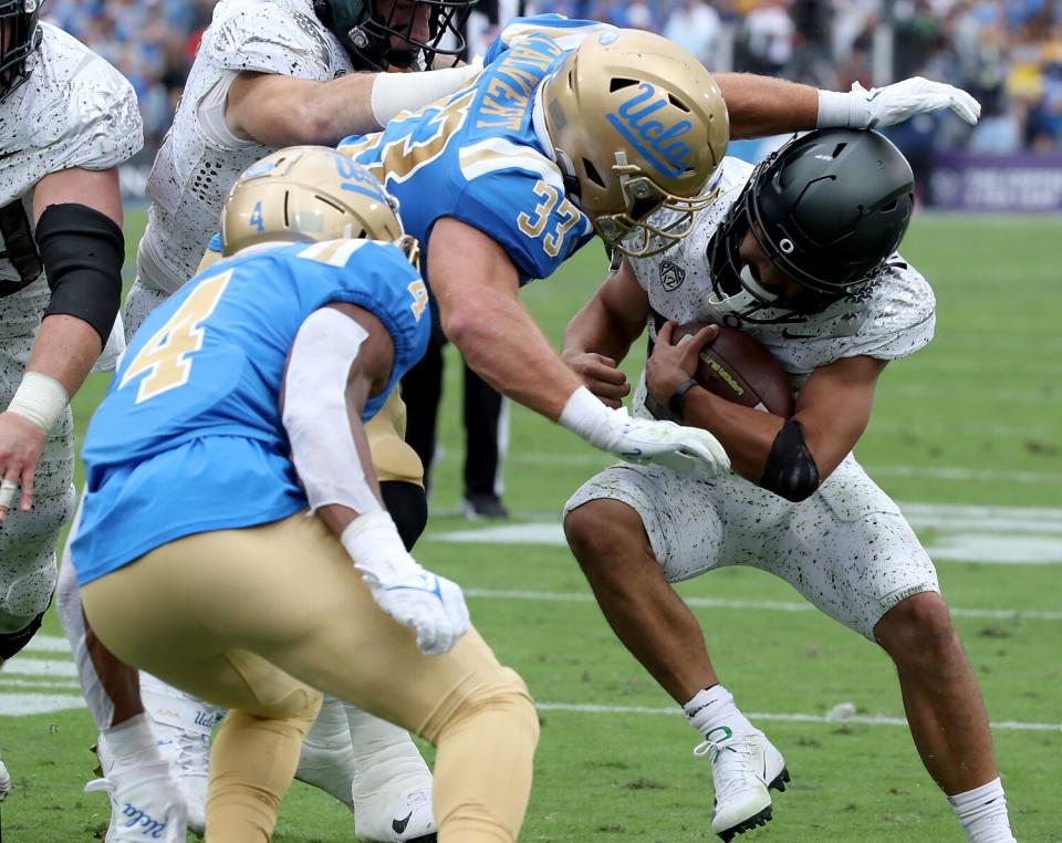 UCLA linebacker Bo Calvert tackles Oregon running back Travis Dye.