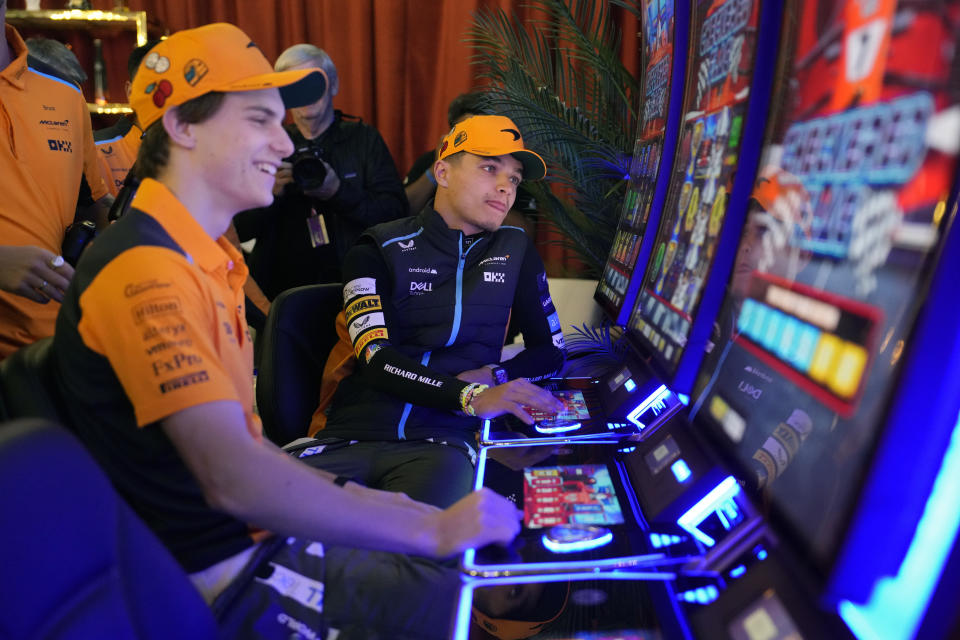 McLaren driver Oscar Piastri, of Australia, left, and McLaren driver Lando Norris, of Britain, sit at mock slot machines before an opening ceremony for the Formula One Las Vegas Grand Prix auto race, Wednesday, Nov. 15, 2023, in Las Vegas. (AP Photo/John Locher)