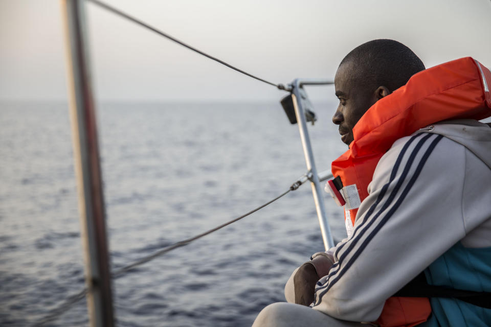 A migrant rests on a Mediterranea Saving Humans NGO boat, as they sail off Italy's southernmost island of Lampedusa, just outside Italian territorial waters, on Thursday, July 4, 2019. An Italian humanitarian group whose boat has been barred from docking in Lampedusa said the health of the 54 migrants it rescued at sea is rapidly deteriorating, prompting fears of another standoff with Italy's populist government. Mediterranea Saving Humans said Friday in a tweet that its sailing boat ALEX was off Italy's southernmost island of Lampedusa, just outside Italian territorial waters, and that it has been banned from entering Italian jurisdiction by ministerial decree. (AP Photo/Olmo Calvo)