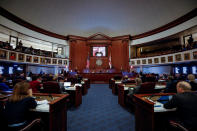 <p>Members of the Florida Senate watch as photos of the victims of Marjory Stoneman Douglas High School mass shooting are projected on the screen in their darkened chamber at the Capitol in Tallahassee, Fla., Feb. 21, 2018. (Photo: Colin Hackley/Reuters) </p>