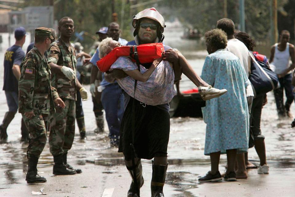 <p>A woman is carried out of flood waters after being trapped in her home during Hurricane Katrina. Katrina made landfall as a Category 4 storm with sustained winds in excess of 135 mph. </p>