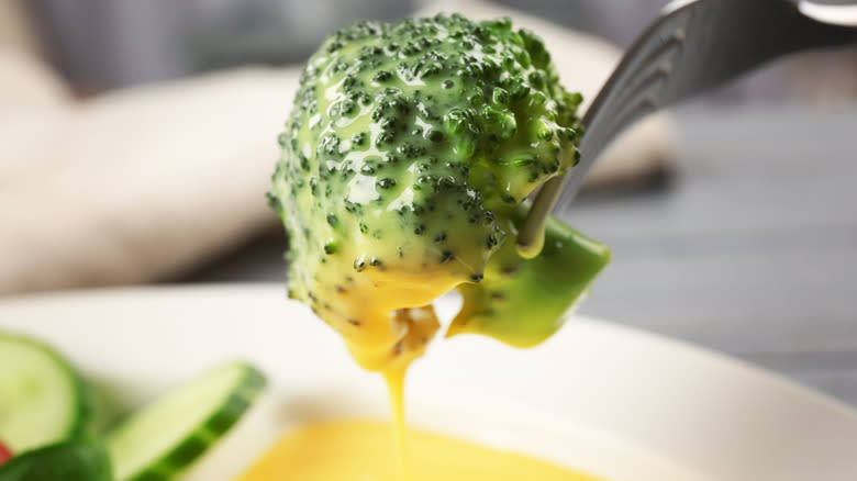 Dipping broccoli floret in dip with fork